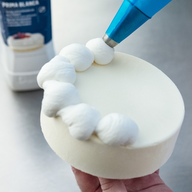 Spuit een cirkel van doppen aan de rand van de taart.