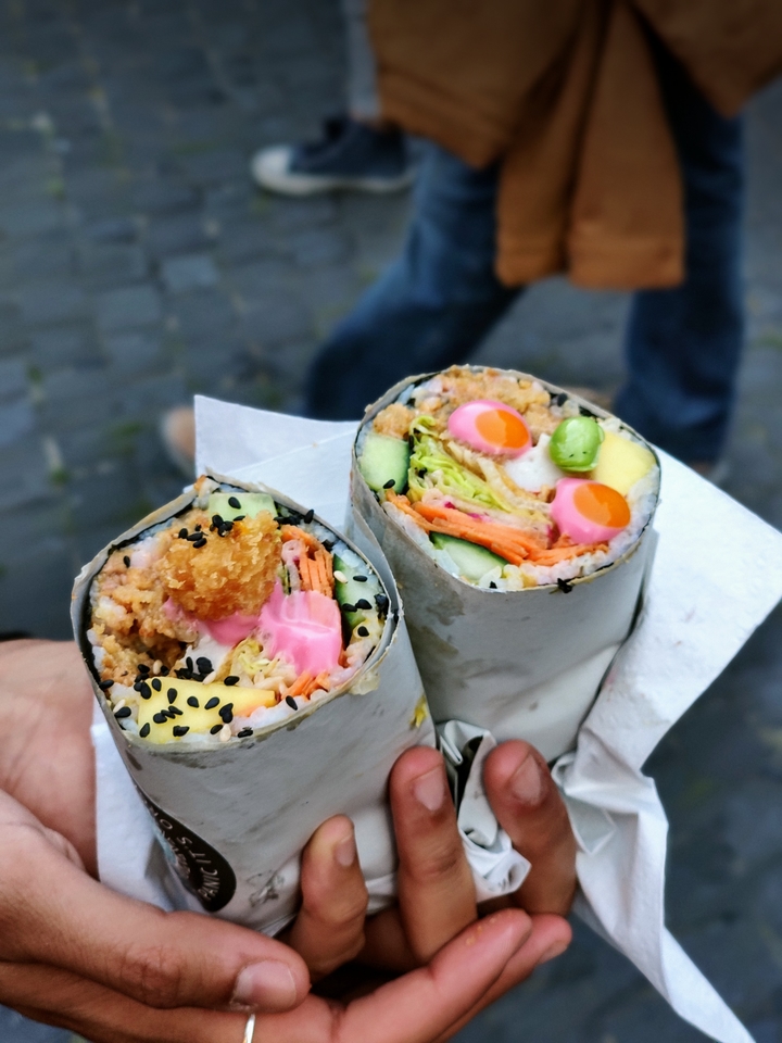 Sushi burrito met verse vis, groenten en rijst.