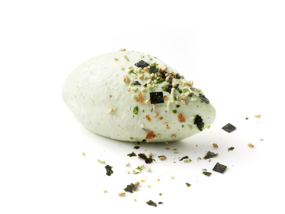 A green herb‑speckled quenelle topped with mixed seasoning and seaweed flakes