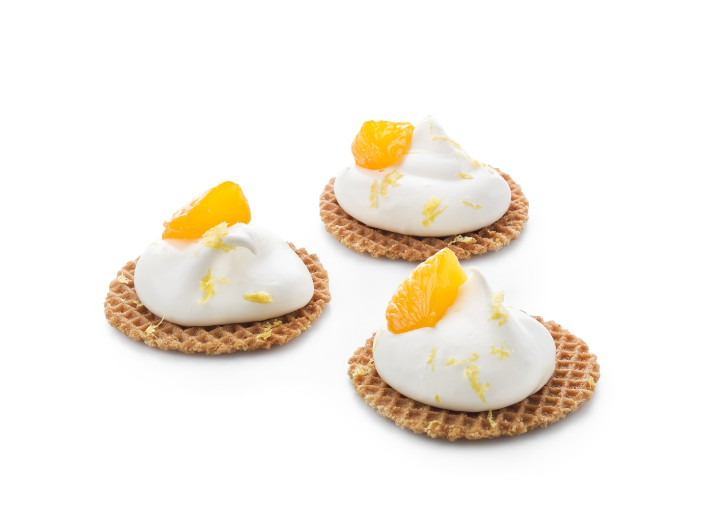 Mini stroopwafels garnis de crème fouettée et de morceaux de mandarine