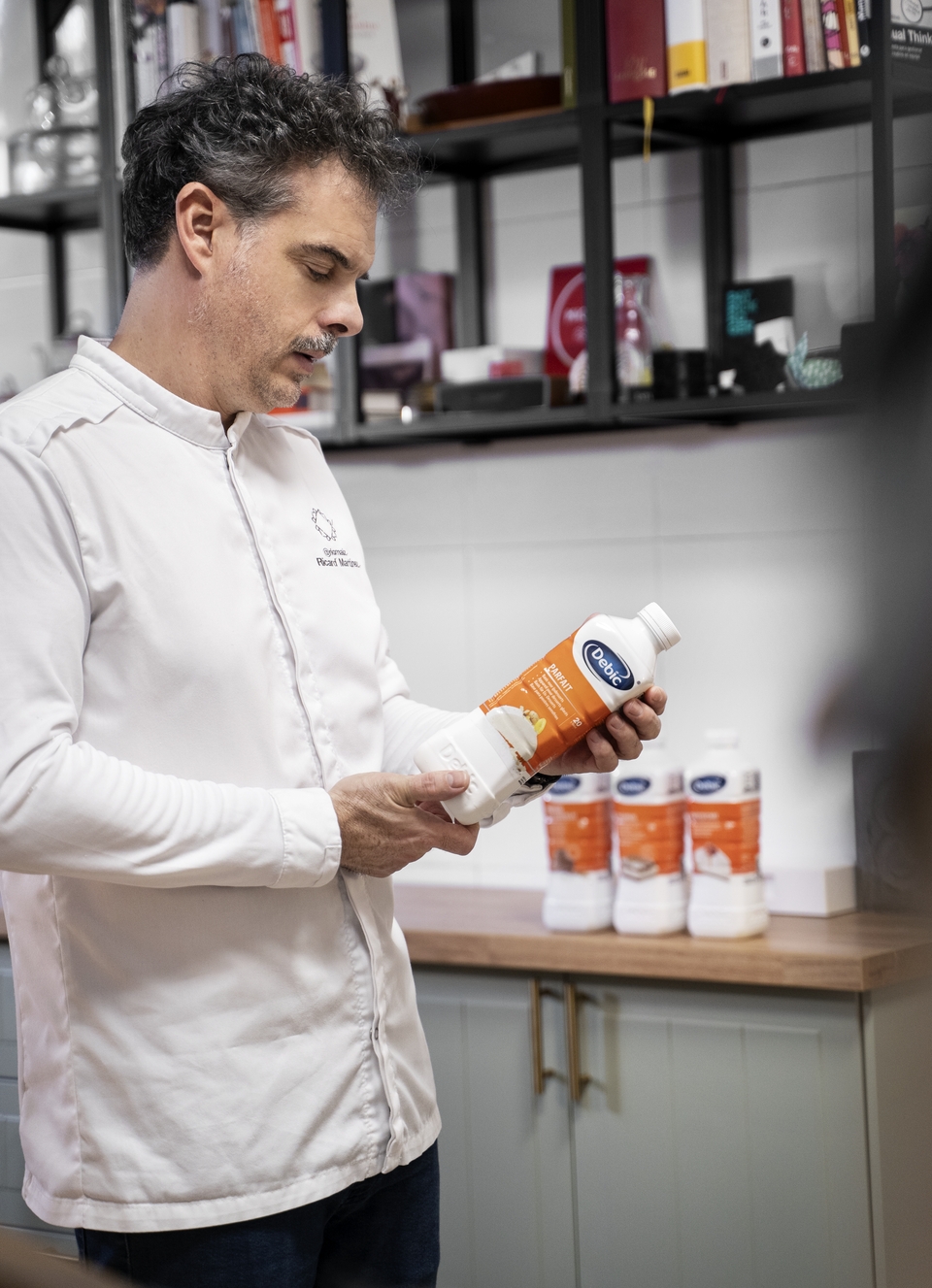 Ricard Martínez holding a bottle of Debic Parfait