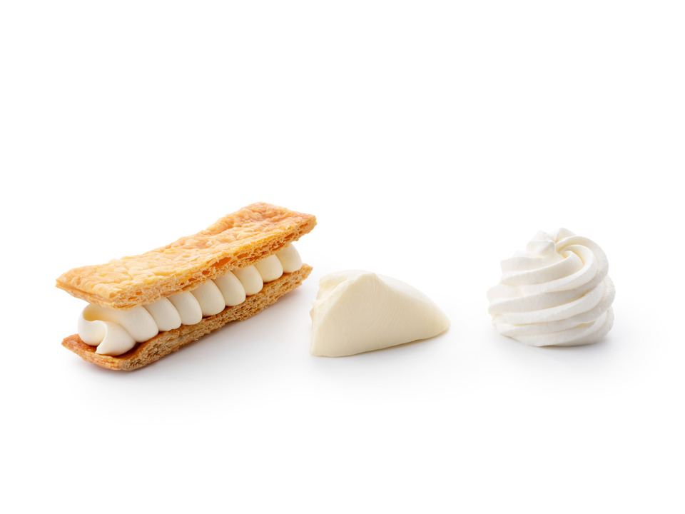 Three applications of Debic Tiramisù on a white background: crème suisse piped between layers of puff pastry, a smooth dollop of crémeux, and a swirled rosette of light chantilly cream.
