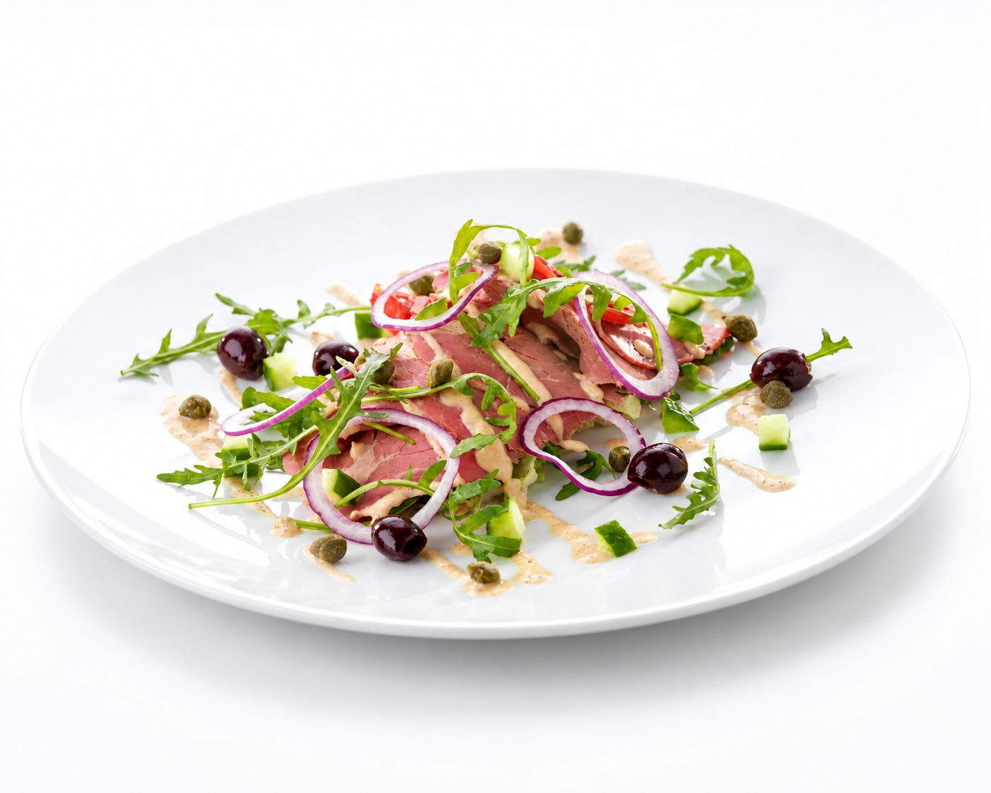 Vitello tonnato with sliced veal, arugula, red onion, capers, olives, and creamy tuna dressing on a white plate.