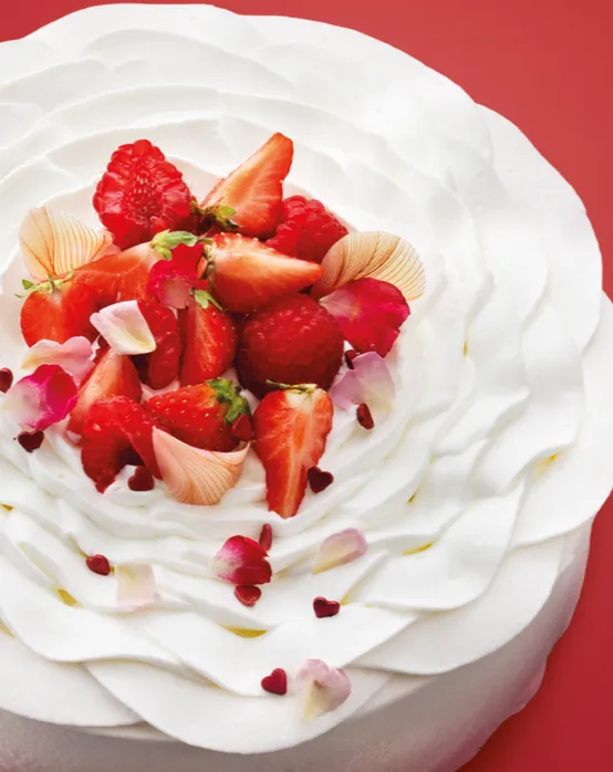 Strawberry‑topped frosted cake on a red background